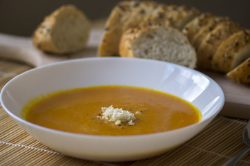 Tasty pumpkin soup with horseradish and fresh multigrain baguette