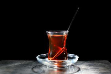 Hot tea in traditional turkish bardak glass, isolated on black background