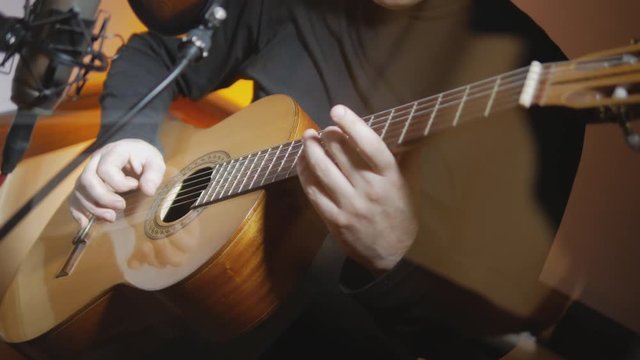 4k Middle age man plays music by acoustic guitar at sound recording studio close