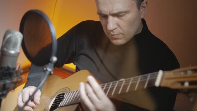 4k Musician plays classic songs by vintage acoustic guitar during recording