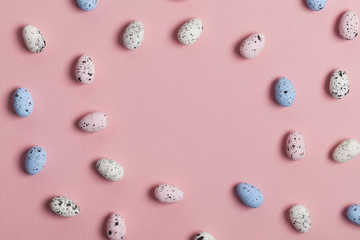 A collection of easter eggs on a pastel pink background