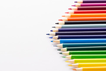 Obraz premium Several colored pencils on a white background with copy space