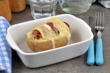 Pomme de terre fourrée avec du fromage et du jambon dans un plat