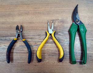 Florist tools, florist work. Secateurs for working with plants, nippers on a wooden background