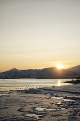Sun Setting behind Snow Covered Mountains
