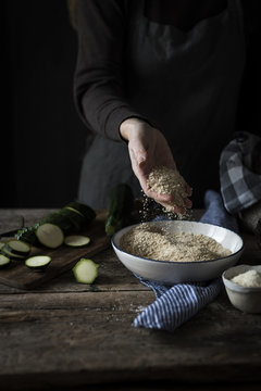 Close up of woman's hand holding breadcrumbs in plate
