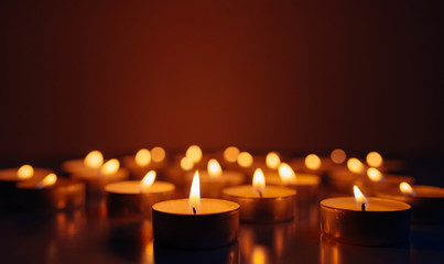 Burning candles. Shallow depth of field. Many christmas candles burning at night. Abstract candles background. Many candle flames glowing on dark background. Close-up. Free space.