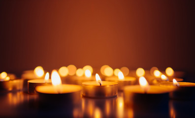 Burning candles. Shallow depth of field. Many christmas candles burning at night. Abstract candles background. Many candle flames glowing on dark background. Close-up. Free space.