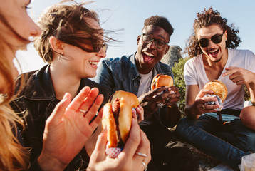 Group of friends eating burger on mountain top - obrazy, fototapety, plakaty