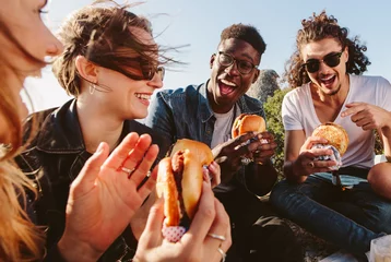 Zelfklevend Fotobehang Group of friends eating burger on mountain top © Jacob Lund