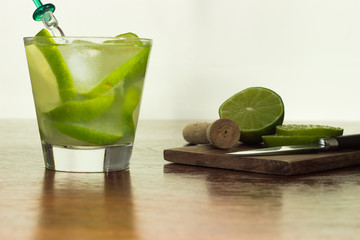 A glass of Caipirinha, is the most famous brazilian drink - lemon cachaca and ice - wood board -...