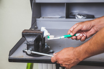 squeezes toothpaste from tube with vise