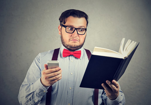 Puzzled man confused with book and phone
