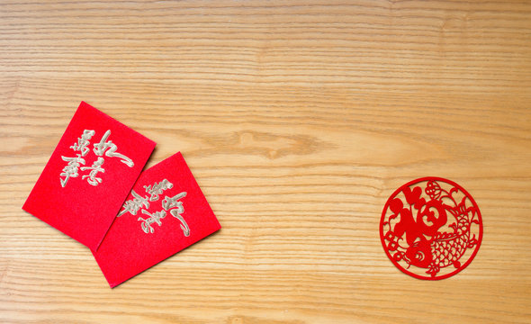 traidtional Chinese red pockets and paper cut on table  the Chinese means everything is as wishes
