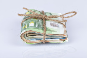 A bundle of euro bills tied with a rope and placed on white