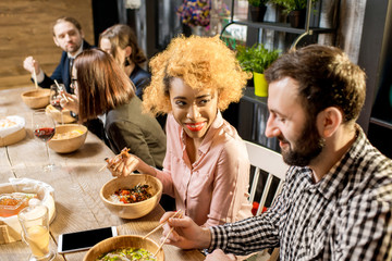 Beautiful multi ethnic couple sitting during the dinner with asian food in the restaurant