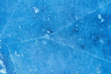 beautiful blue background of ice with cracks and bubbles 