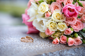 wedding bouquet and wedding rings for bride and groom. the bride's bouquet of roses and wedding rings	