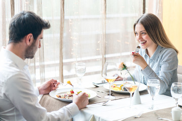 food, christmas, holidays and people concept - smiling couple eating main course at restaurant