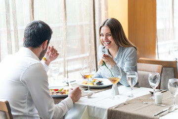 food, christmas, holidays and people concept - smiling couple eating main course at restaurant