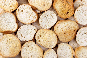 Background from many small round rusks on wooden table. Top view