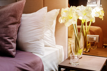 Bed maid-up with clean white pillows and bed sheets in beauty room. Close-up. Lens flair in sunlight.