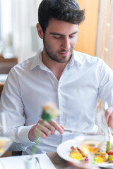 Young man eating a healthy food at restaurant