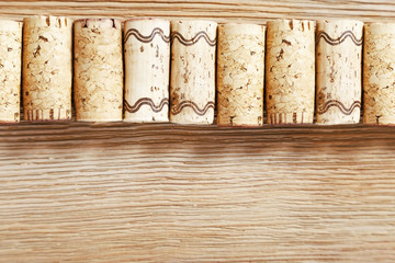 A row of old wine corks on a wooden background. Top view. Selective focus on corks.