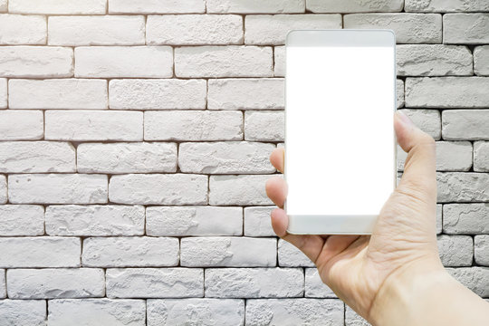 hand with white screen smartphone with old rustic brick wall texture background and free copy space for your ideas text