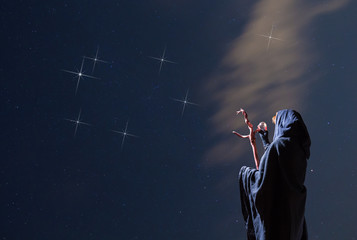 eine mysteriöse Frau betrachtet in der Nacht ein Sternbild
