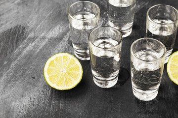 Cold vodka in shot glasses on a black background