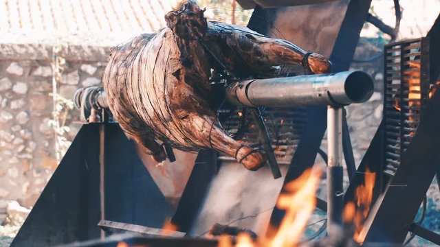 Whole bull carcass fried on spit on Medieval Fiesta in Besalu, Spain