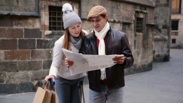 Smiling couple man and woman in the historic center with map in autumn