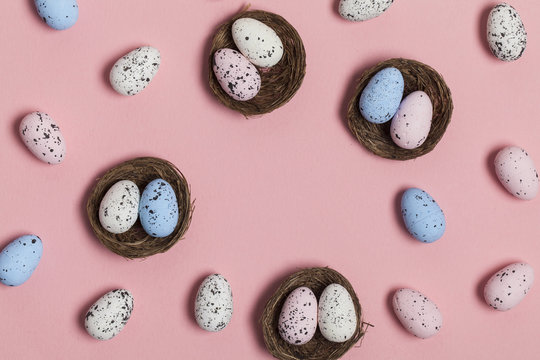 Easter eggs in a nest on a pastel pink background
