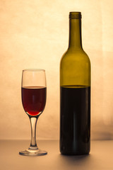 Bottle and a glass of wine on a light background