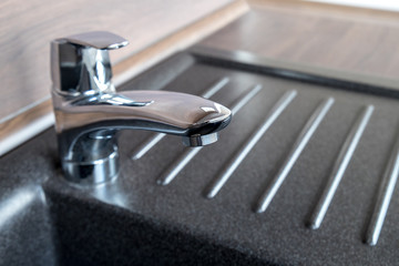 Shiny chrome faucet in a brand new kitchen