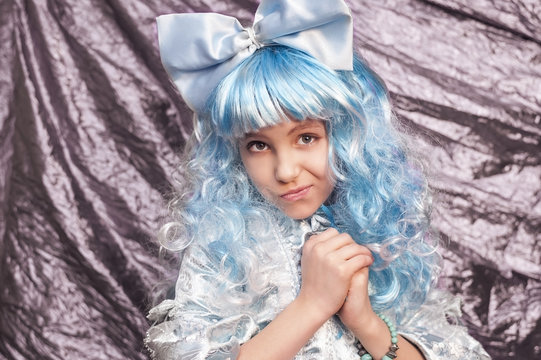 A cute young girl dressed in a blue carnival costume of Malvina