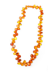 Amber beads on white background. Beads from polished pieces of amber of ancient petrified resin....