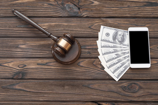 hammer judge, smartphone, dollar bills on a wooden background. lawyer. jurisprudence.