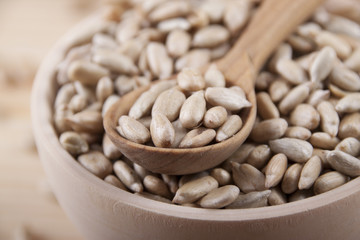 Sunflower seeds in a wooden bowl and a wooden spoon