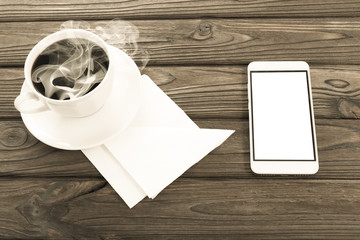 a cup of coffee, paper napkins, a smartphone. breakfast.