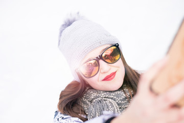 beautiful young woman taking a selfie in winter nature. Pretty woman taking a photo in a nature. Winter background. 