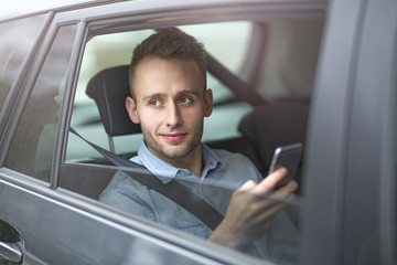 Young man sitting in a taxi
