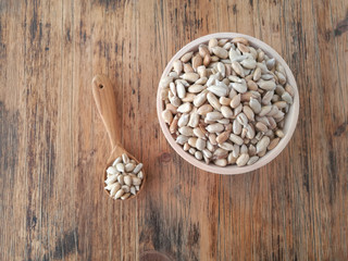 Sunflower seeds in a wooden bowl and a wooden spoon