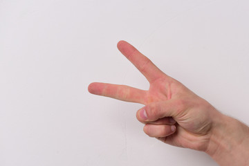 Male hand shows two fingers. Hand gesture expresses victory.