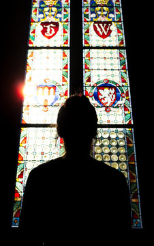 Girl looking at the colorful of windows of an old castle in Prague, Czech Republic.