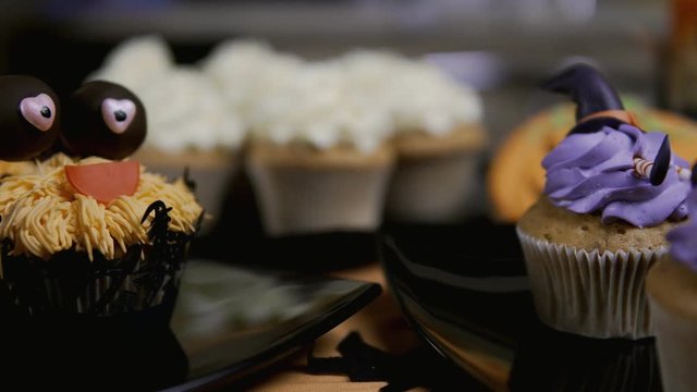 Cupcakes with icing hat and legs. Delicious Muffin like witch. Halloween concept in 4k, UHD