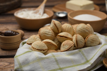 homemade cookies shaped nuts with cream boiled condensed milk on wooden table. Rustic style