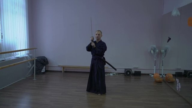 Samurai Performs Kata Kendo with Katana's Sword in the Sports Hall