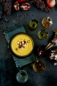 Wine Roasted Vegetable Bisque served with bread and wine. Photographed on a dark blue background.